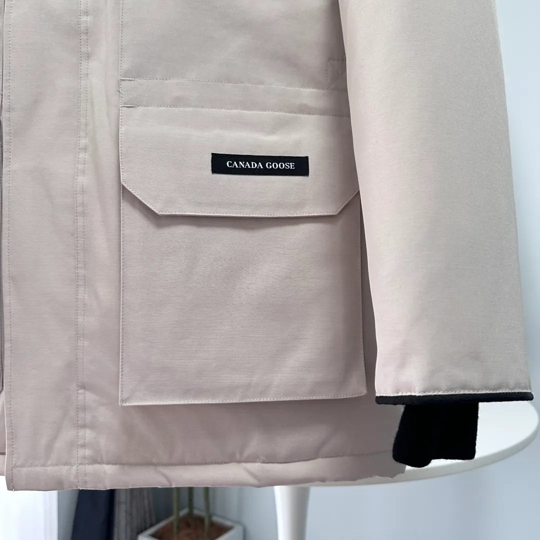 P700 CANADA GOOSE｜Canada Goose Expedition Parka｜Classic upgrade New 08 style Color: graphite gray, off-white, black, pink, navy blue, sky blue, Size: XS, S, M, L, XL, XXL, Product introduction Loose fit, multi-pocket design Larger size for free movement. 6 exterior pockets: 4 reversible front pockets, zippered side entry. There is a practical pocket on the left sleeve and a top pocket on the right sleeve. There is a drawstring on the inside of the waist and a logo patch on the back. The waist is designed with an inside drawstring, which can be adjusted to provide excellent warmth. Woven grab straps at upper back with “Expedition” logo patch • Hood with removable zipper trim, interchangeable hood trim for personalization and added protection (this jacket is not available with the classic hood trim) • Chin protection element has a tricot inner fabric for softness and comfort • Woven grab straps at upper back with “Expedition” logo patch • Internal drawstring at the waist, adjustable to provide excellent warmth •Snap-in rib knit cuffs for added comfort and optimal heat locking in •Stylish hanging inner straps allow the jacket to be carried over the shoulder, hands-free •Stowaway nylon stretch snow skirt for added protection •Two-way zipper covered fly with Velcro® snaps that unzips from the bottom for increased range of motion and breathability. A windproof fly is designed under the zipper for an extra layer of protection. • 6 exterior pockets: 4 two-way pockets on the front with top flap and Velcro® snaps, and zippered side entry. Utility pockets on left sleeve and right sleeve with top flap and velcro® snaps Internal pockets: 1 zipped pocket, 2 mesh drop-in pockets Embroidered Canada Goose logo